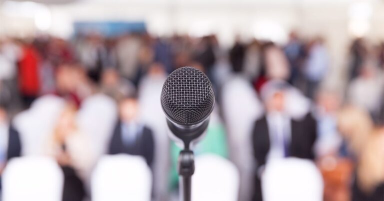 microphone in front of blurred conference audience GettyImages 1025077504 1200w 628h